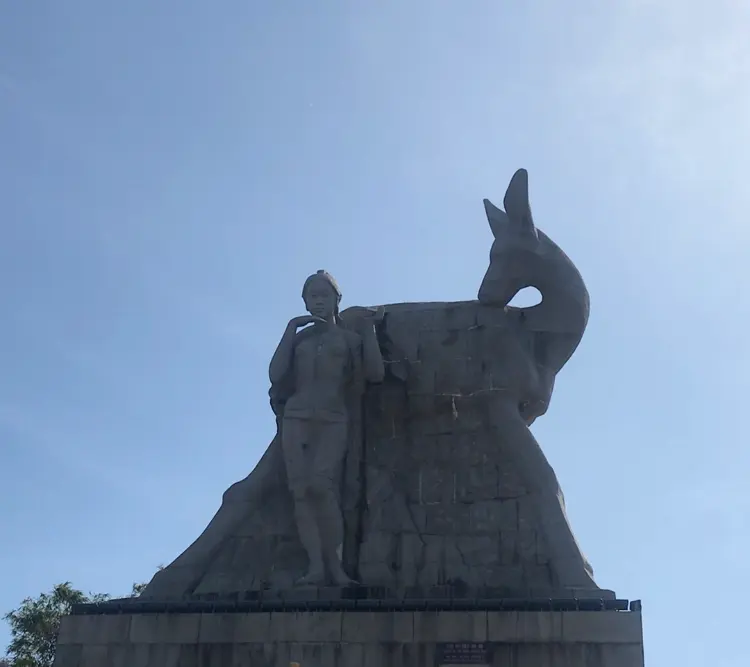 鹿回头石雕：一女子与鹿的照片